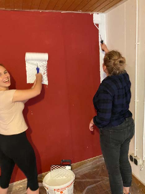 Zwei junge Frauen weisseln Wände des Jugendkellers, evangelische Kirche Solln